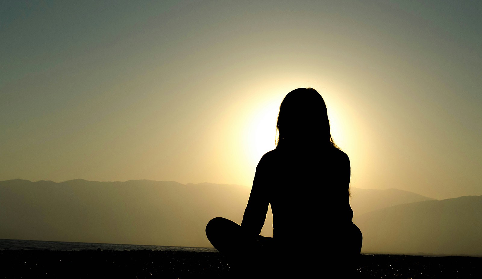 A calm figure at sunset, hiding the physiological signs of burnout