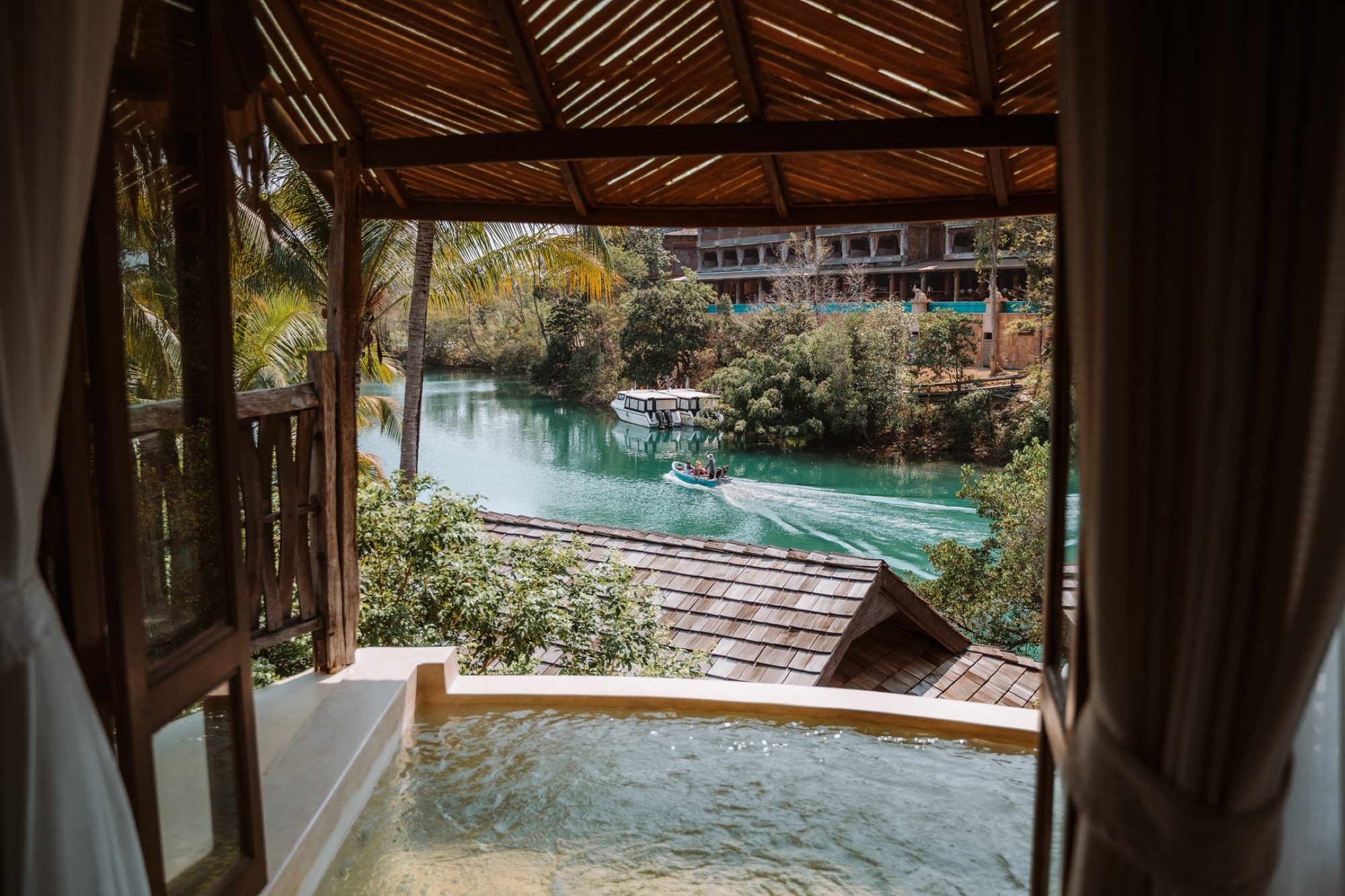 A riverside wellness villa in Thailand at golden hour.